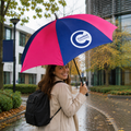 Young woman holding a blue and pink cranfield university umbrella 