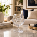 Cranfield University goblet glass on a marble surface with a cozy living room background